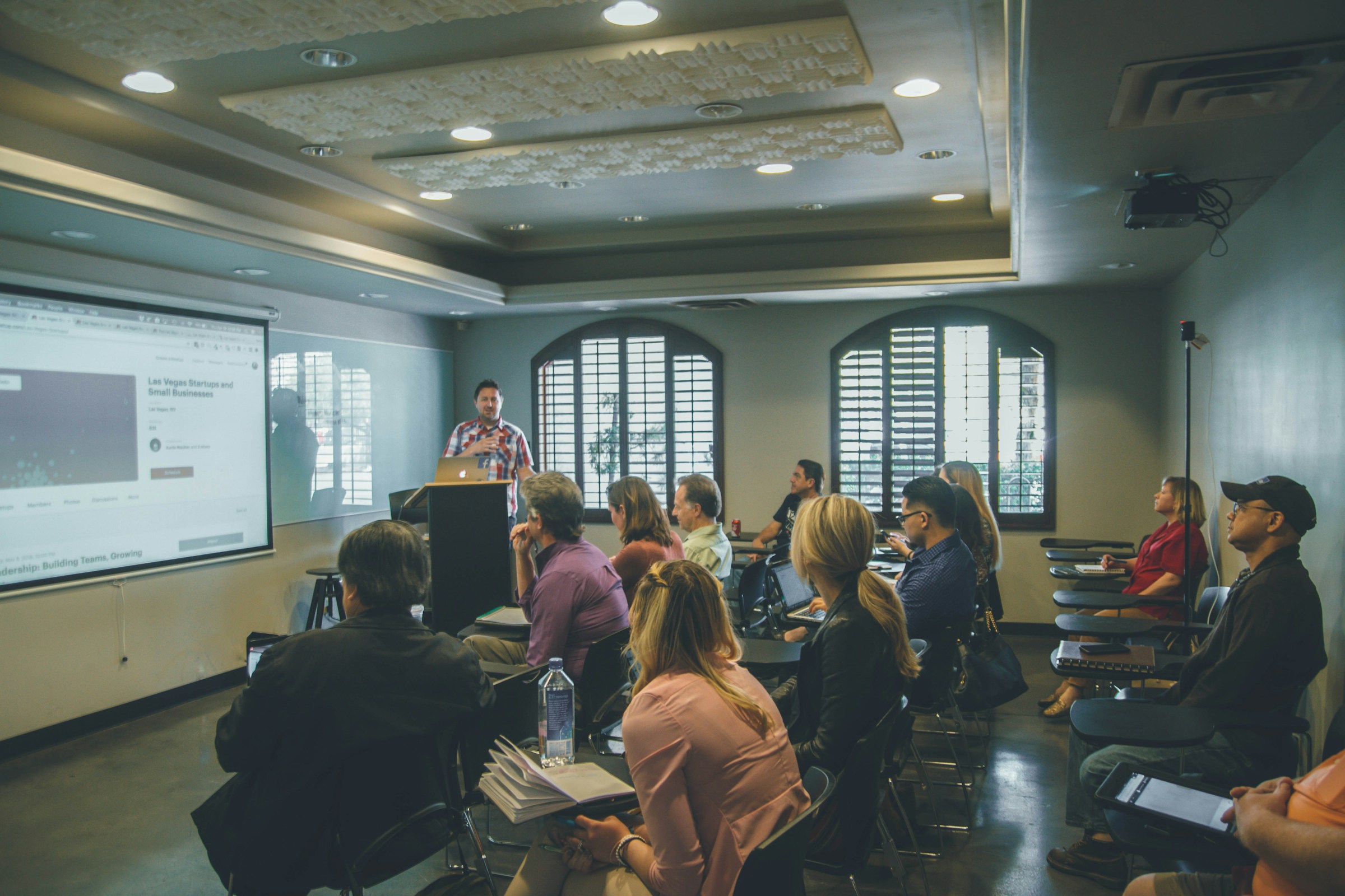 A speaker leading a corporate seminar in a modern conference room.